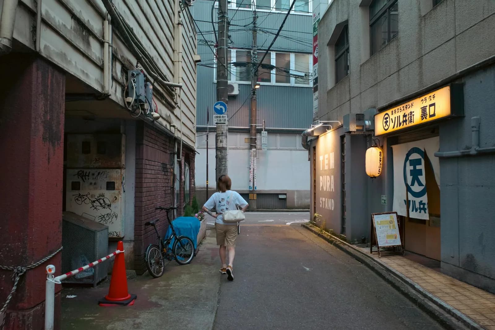 Woman walking alone through a quiet residential street in Fukuoka