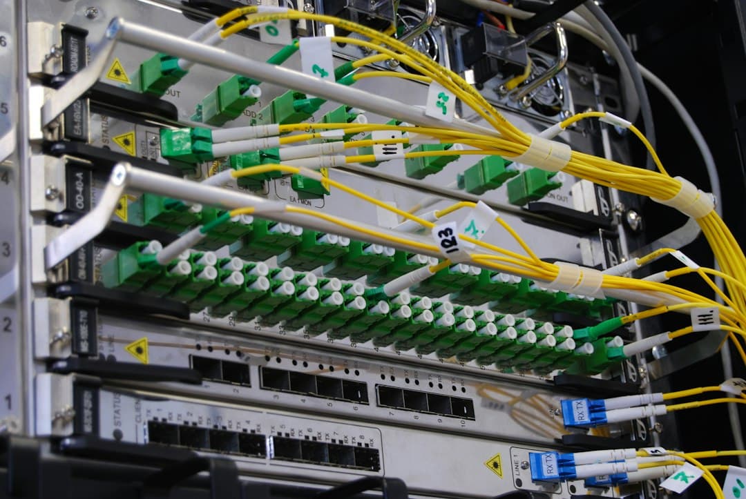 Armario de servidores con cables de fibra óptica amarillos y puertos de red verdes que muestran la infraestructura de internet.