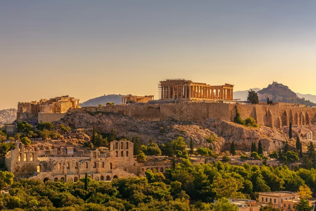 The Acropolis of Athens with the Parthenon on an ancient hill at sunset, Mediterranean landscape.