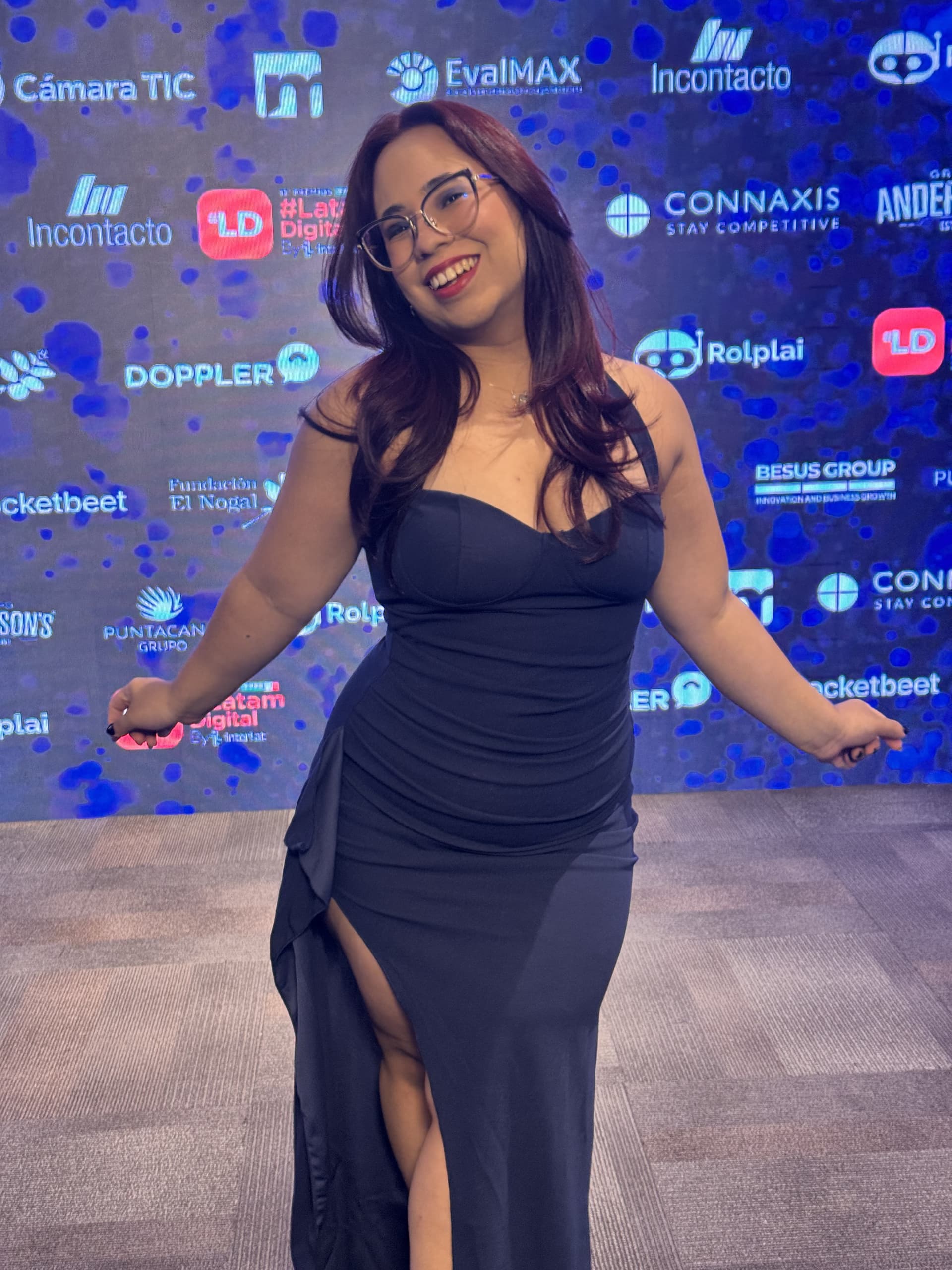 Daniela Morán, wearing a black dress, poses in front of the Latam Digital Awards partner wall.