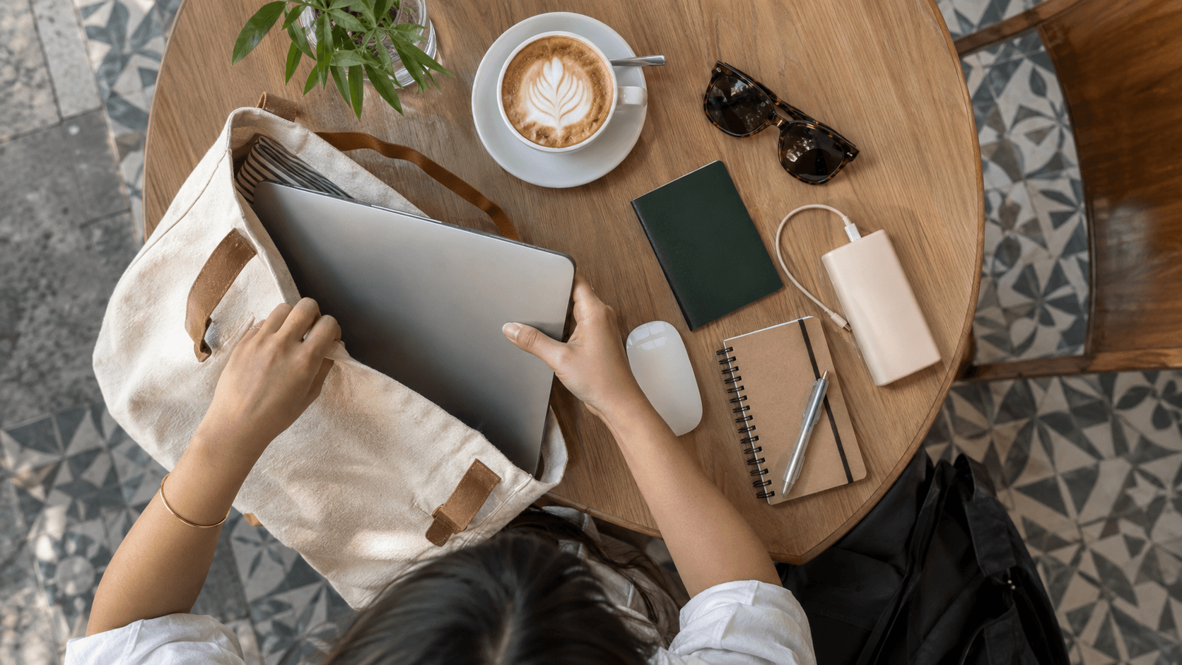 Passport and travel documents on a workspace with a laptop and a cup of coffee.