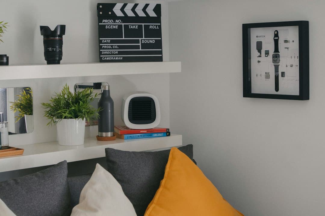 Router Wi-Fi compacto sobre una estantería de salón con plantas y objetos decorativos.