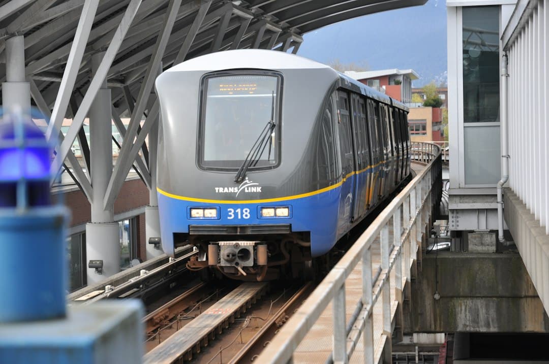 Elevated Vancouver SkyTrain car at the station in blue and white livery.