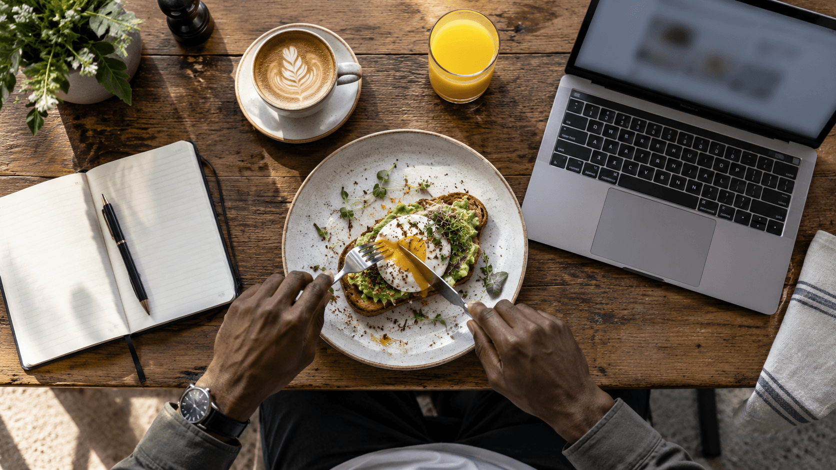 Digital nomad working at a café table with a laptop, coffee, and a meal in Japan.