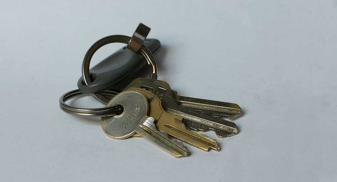 Plusieurs clés en laiton sur un porte-clés, symbolisant l'accès à un appartement et les frais d'entrée.