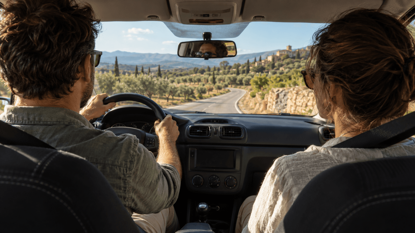 Couple conduisant à travers le paysage vallonné de l'Alentejo avec cyprès et oliveraies sur route de campagne.