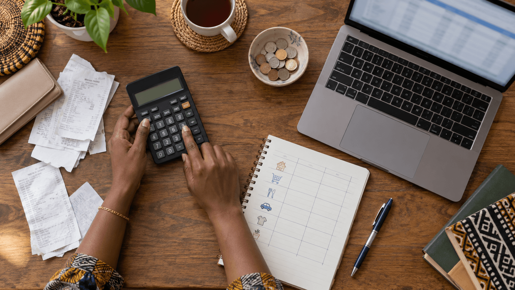 Person calculating taxes with documents, calculator, laptop and receipts on the desk