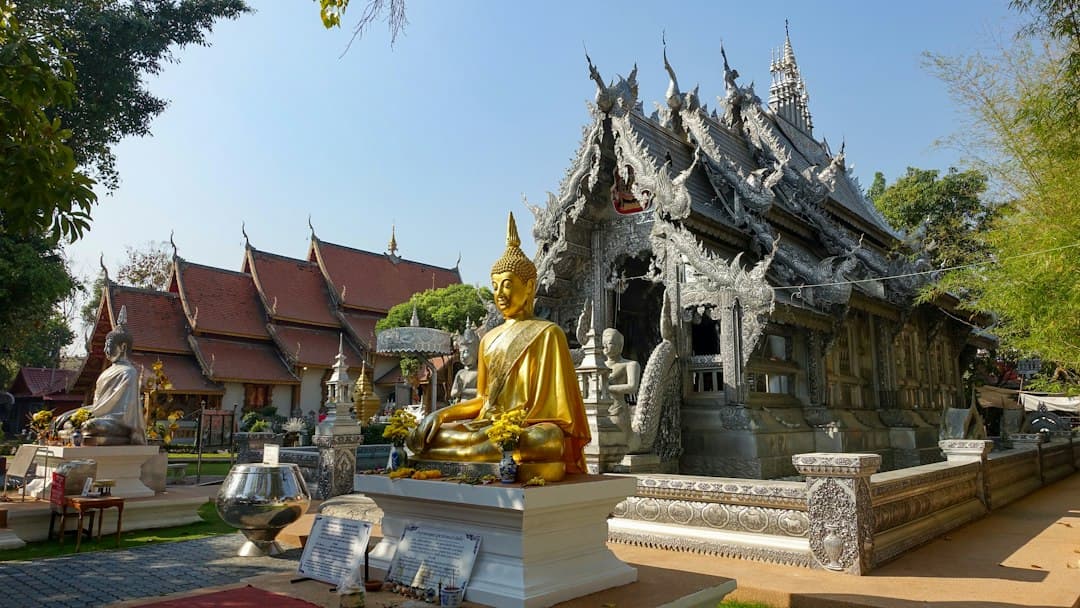 Temple bouddhiste traditionnel avec statue de Bouddha dorée et architecture ornée dans la vieille ville de Chiang Mai.