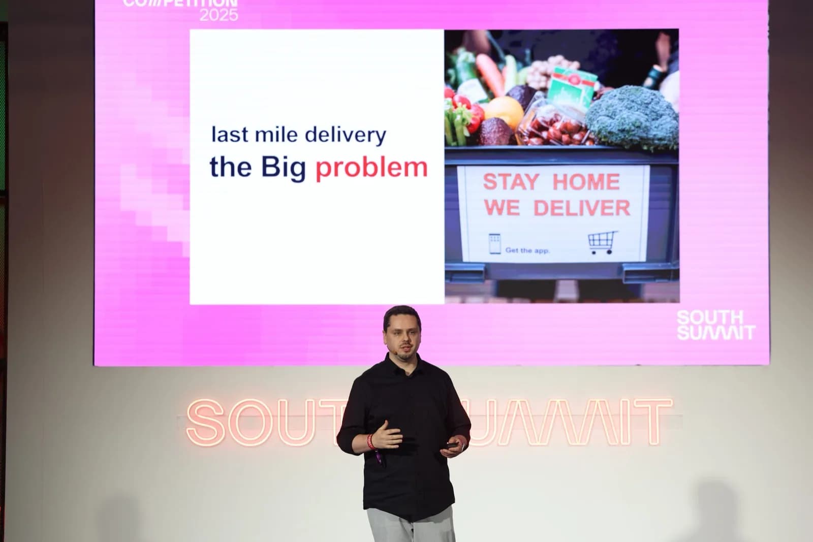 Cédric Tumminello on stage at South Summit 2025, wearing a black shirt, in front of a presentation screen