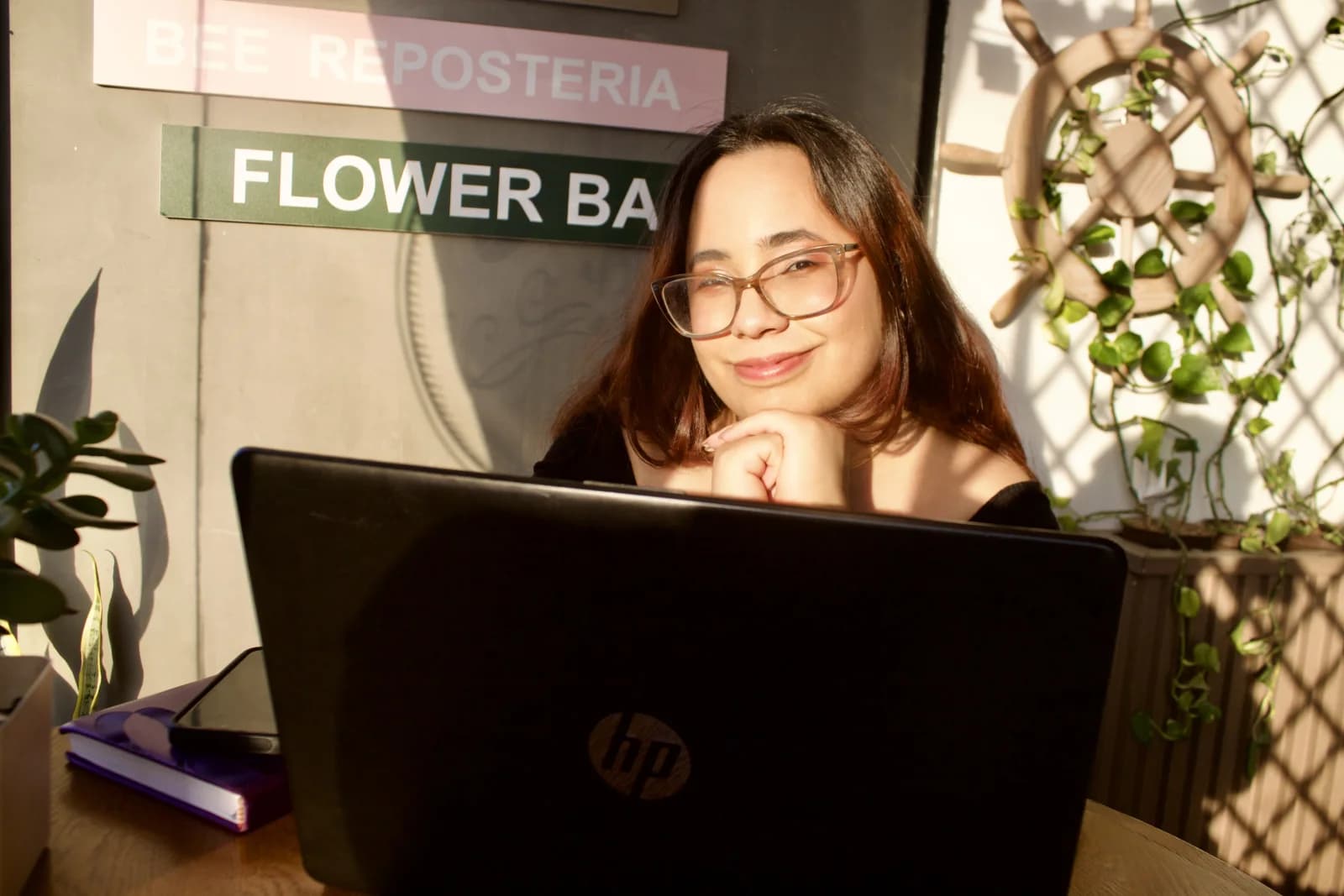Daniela Morán working on her laptop in a bright café