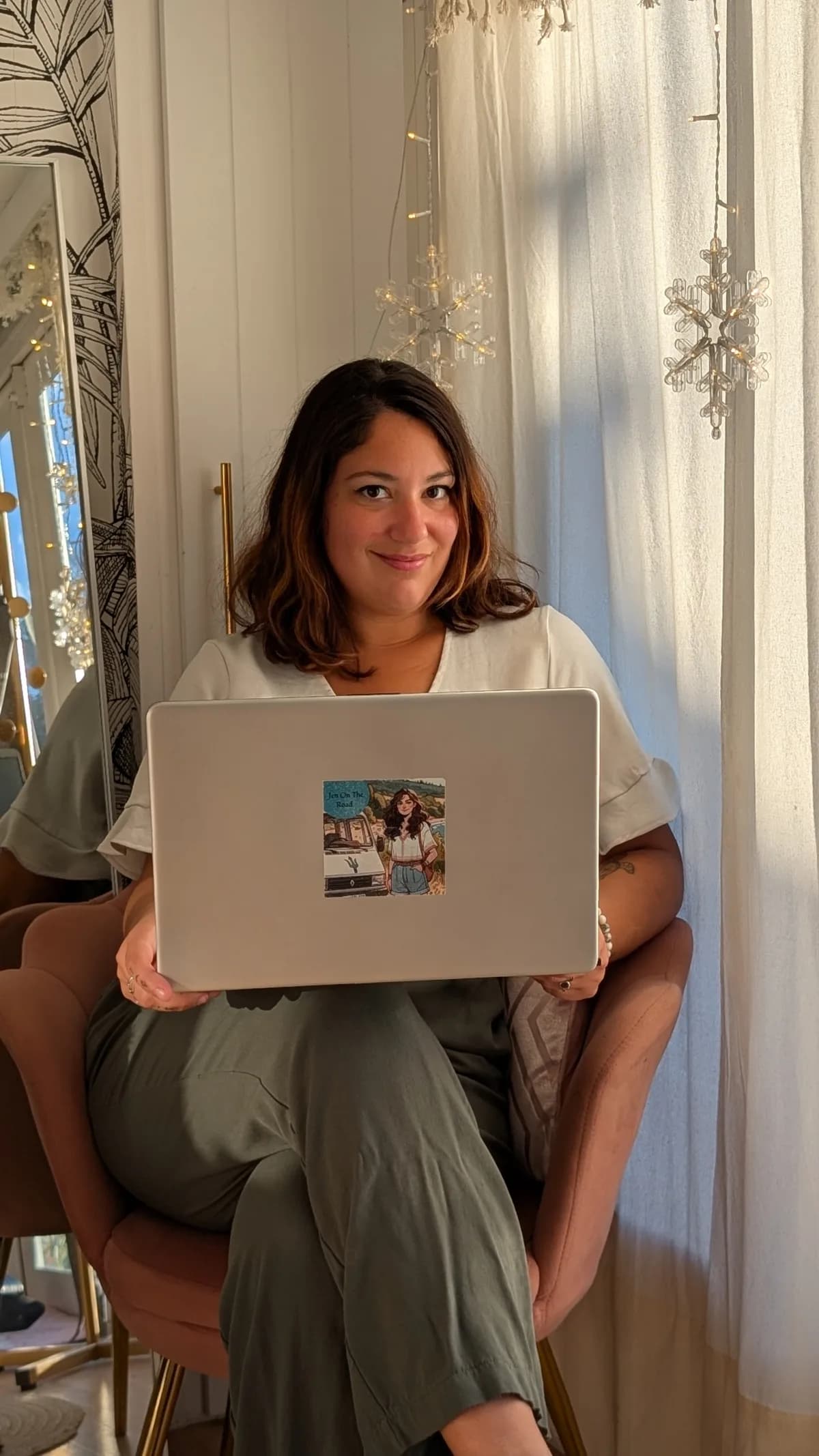 Jennifer Therond, assise avec son ordinateur portable sur les genoux, regarde l’objectif