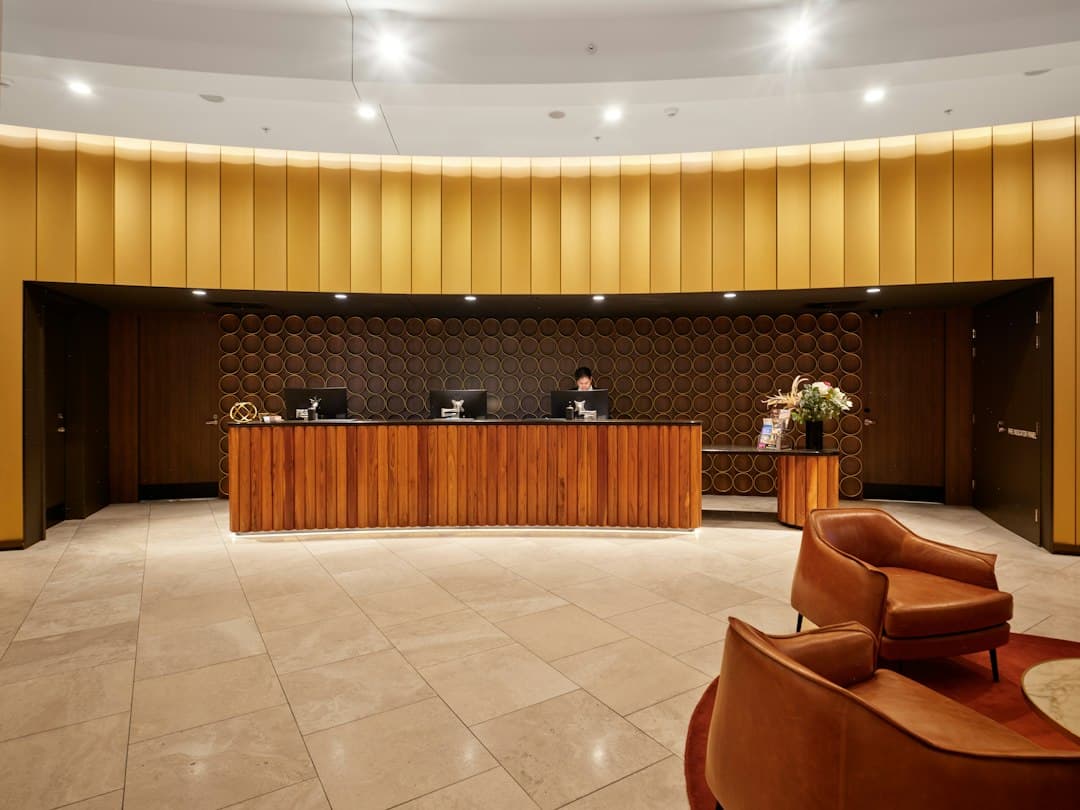 Reception di un hotel con personale in un moderno atrio, che rappresenta il servizio clienti e l'assistenza.