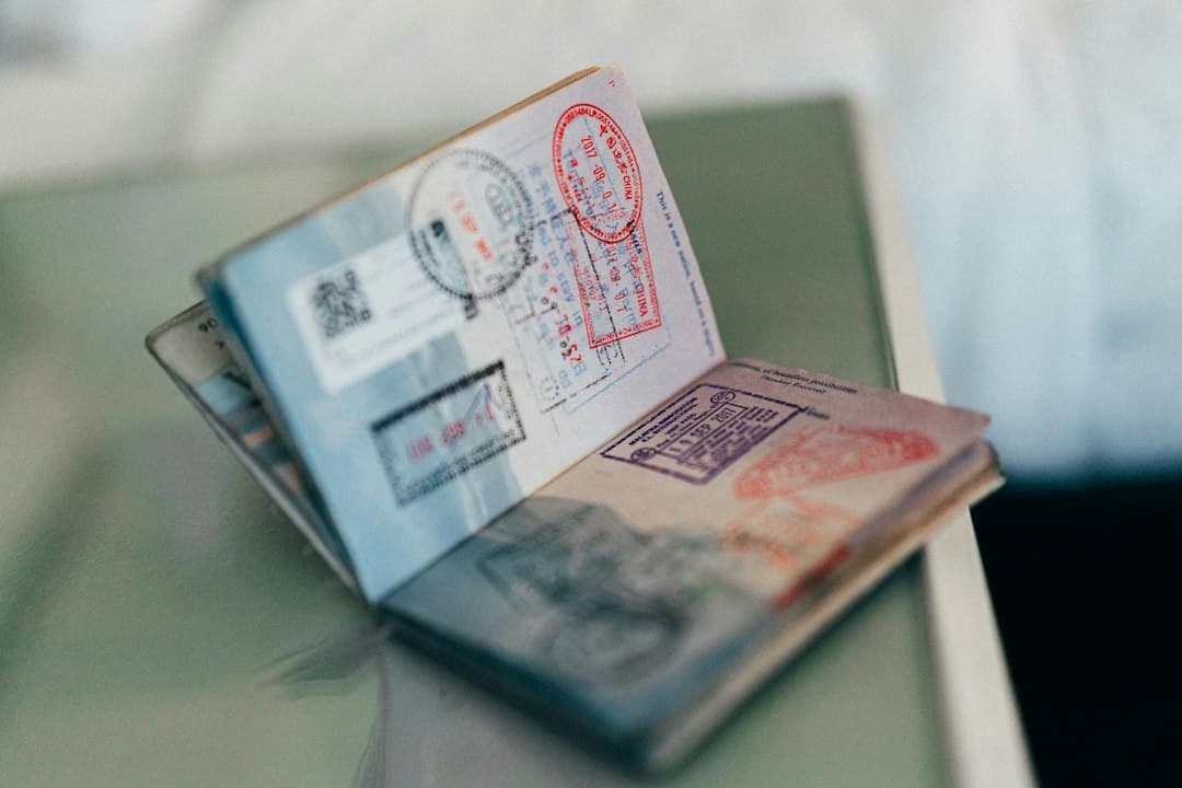 An open passport with several visa stamps on a table.