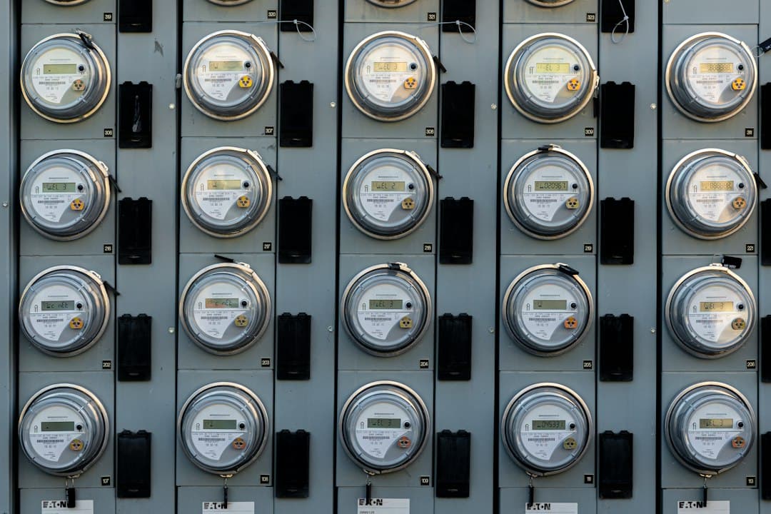 A grid of several residential electric meters mounted on a wall.