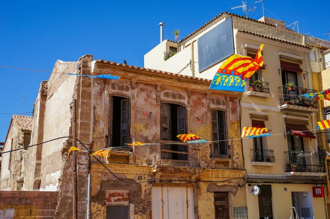 Historic buildings in the old town with Catalan flags under a blue sky, Spain.