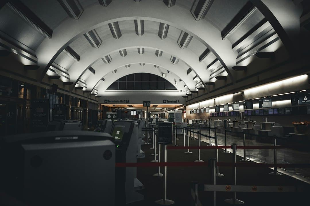 Empty airport immigration hall with several counters and modern ceiling lighting.