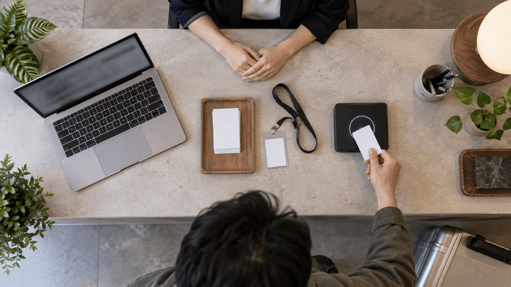 Digital nomad working at a desk with a laptop, notebook, and phone in a modern coworking space.